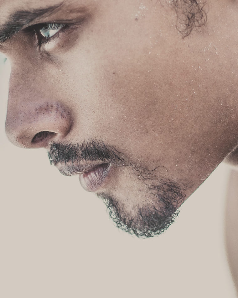 Close-up profile of a man in soft daylight, jaw and beard line in focus