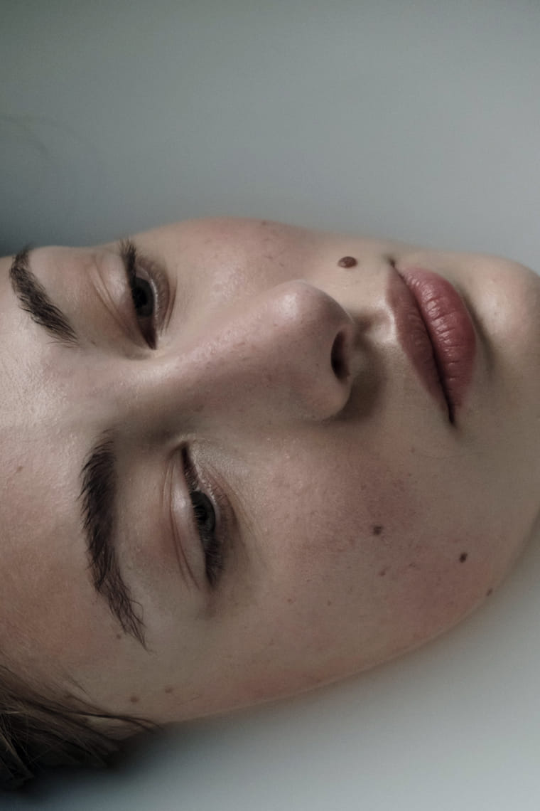 A close portrait in soft daylight, the face relaxed and turned slightly away